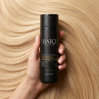 Hair Atelier Nourishing Shampoo held in hand for smooth healthy hair
